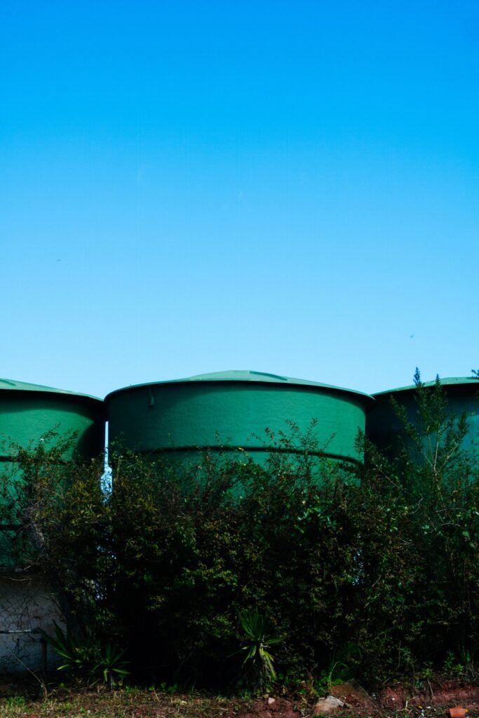Cisternas cilindricas de agua apoyadas sobre la tierra en una zona rural