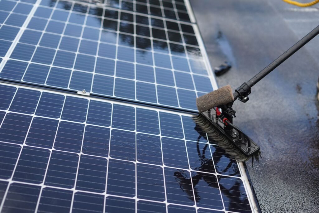 Cepillo limpiando un panel solar, primer plano